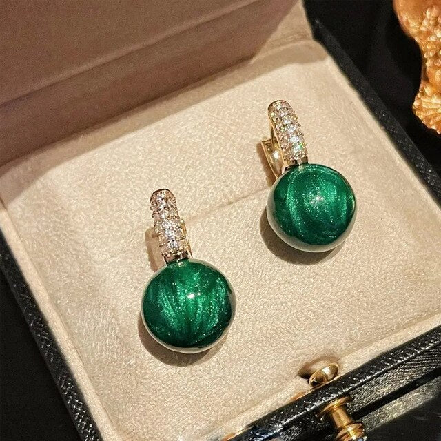 Elegant gold earrings with dazzling green pearls