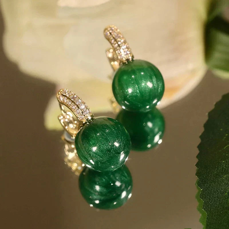 Elegant gold earrings with dazzling green pearls