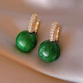Elegant gold earrings with dazzling green pearls