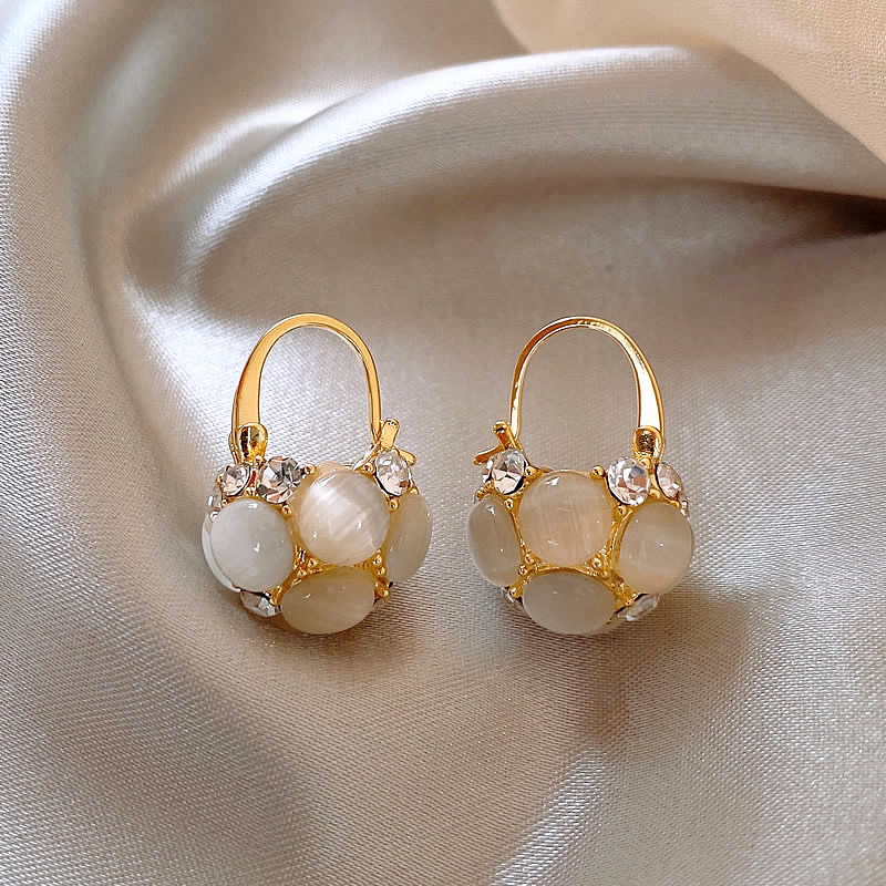 Elegant gold earrings with sparkling crystals and noble pearls